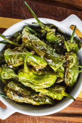 Fried Green Padron Peppers in White Bowl. Pimientos de Padron.