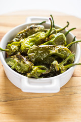 Fried Green Padron Peppers in White Bowl. Pimientos de Padron.