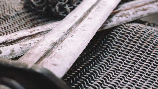 Crossed swords on chain armor, close up, historical ancient weapon concept