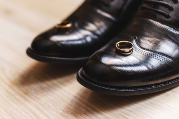 Fototapeta na wymiar Black beautiful shoes for men. Wedding rings. Footwear of the groom. Wedding.