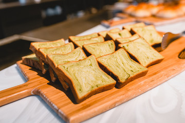 Assortment of baked bread on wooden table background