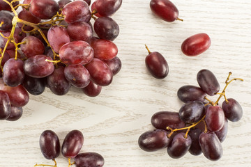Red globe grape berries table top isolated on grey wood background fresh dark pink.