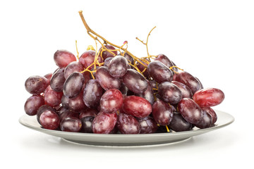 Red globe grape cluster on a grey plate isolated on white background fresh shiny dark pink berries.