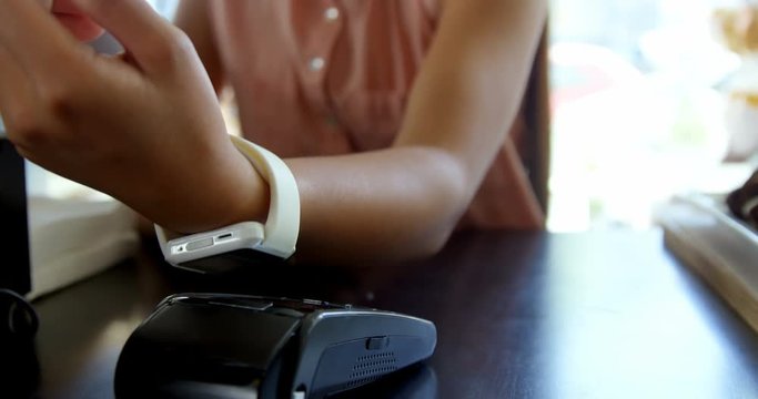 Teenage girl making payment through smartwatch 