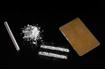white powder is scattered on a black background with a slide, strips are made with a golden color...