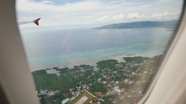 Panorama of the Philippine islands from the window of a flying airplane. Shooting during a flight over the tropical coast. Philippines.