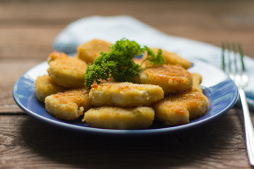 chicken nuggets fried to Golden brown with parsley on wooden background