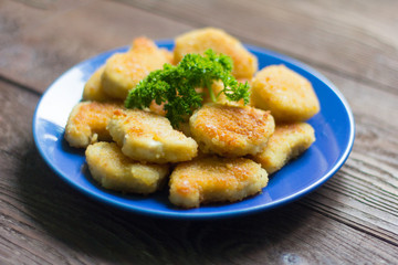Fototapeta premium chicken nuggets fried to Golden brown with parsley on wooden background