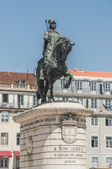 Obraz premium Monument in honor of the king John I (João I) located in the center of Lisbon, Portugal. It is surrounded by buildings typical of the neighborhoods of downtown Lisbon.