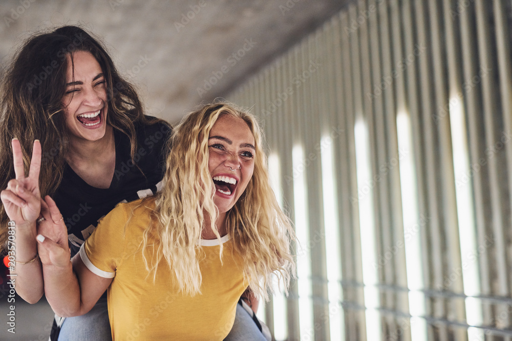 Wall mural Young women having fun together in the city at night