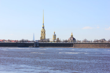 Obraz premium Peter and Paul Fortress in Saint Petersburg City, Russia. Scenic Outdoors View of Popular Tourist Landmark with Neva River Water with melting Ice and Sky Background on Sunny Spring Day Landscape. 