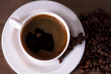 Coffee cup and beans on old kitchen table. Top view with copyspa