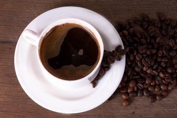 Coffee cup and beans on old kitchen table. Top view with copyspa