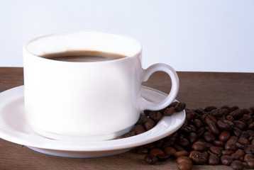 Coffee cup and beans on old kitchen table. Top view with copyspa