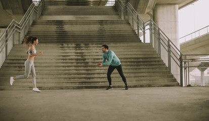 Young woman with trainer exercising in urban enviroment