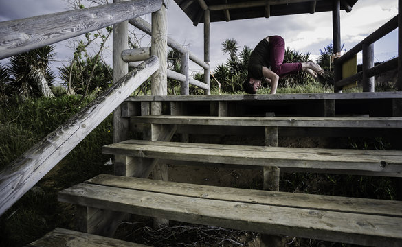 Chico joven realizando ejercicios de yoga en la caba&ntilde;a de madera