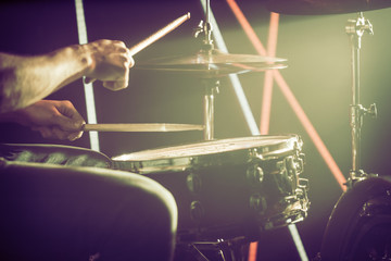 the man plays the drums. On the background of colored lights.