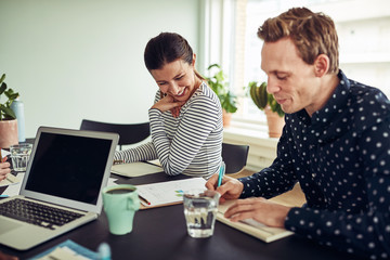 Fototapeta premium Smiling business colleagues going over paperwork together in an