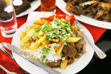 plate with food at a greek restaurant - steak meat with fried potatoes and fresh vegetables