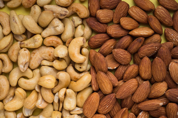 nuts almonds and cashews on a yellow background