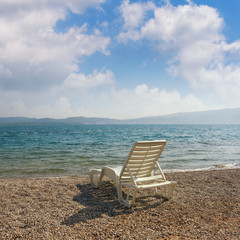Summer vacation concept. Beautiful landscape with one chaise lounge on beach. Montenegro, Bay of Kotor (Adriatic Sea), Tivat