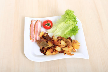 Mięso z ziemniakami i warzywami na białym kwadratowym talerzu. - obrazy, fototapety, plakaty