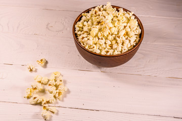 Ceramic bowl with popcorn on wooden table