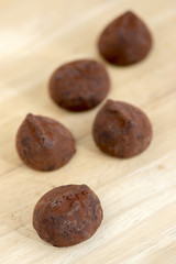 Delicious brown chocolate truffles on wooden table, very tasty sweets