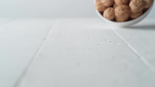 Walnuts in shell rolling on the table. Shot with high speed camera, phantom flex 4K. Slow Motion.