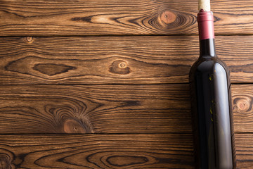 Bottle of red wine against wooden background