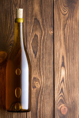 Bottle with white wine against wooden background