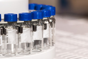 Glass vials for liquid samples. Laboratory equipment for dispensing fluid samples.