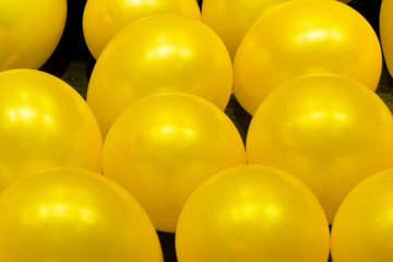 Shiny yellow balloons on black background