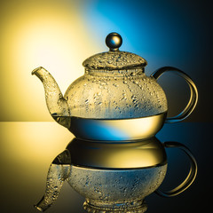 Glass teapot with boiling water and drops of condensation
