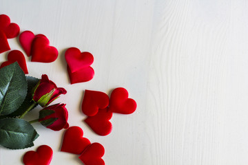 Roses and hearts on white wooden background