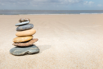 Fototapeta na wymiar concept of Stones balance and harmony pebbles stack on the sand beach during daytime on a sunny day