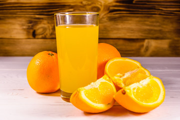 Oranges and glasses with orange juice on a wooden table