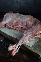 Whole raw lamb and knife on the wooden board. Sheep carcass. Raw meat. Free space for text.
