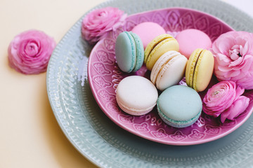 Macaroons and ranunculus on plate.