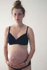 standing woman with big pregnant belly
