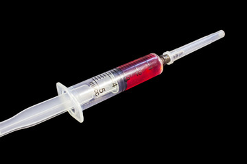 Plastic medical syringe, on black background.