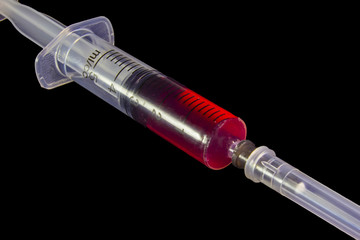 Plastic medical syringe, on black background.