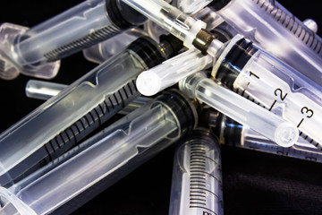 Plastic medical syringe, on black background.