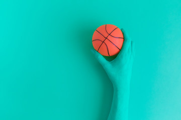 Hand holding basketball ball abstract concept.