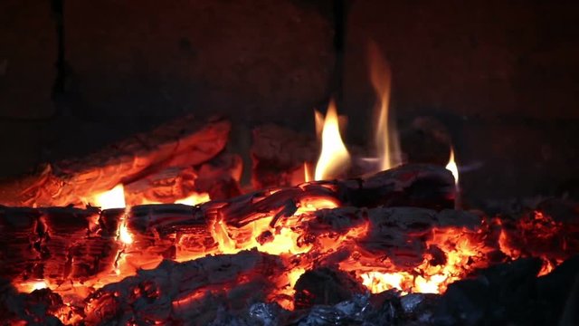 Hot coals and fire flames in fireplace, bonfire close-up.