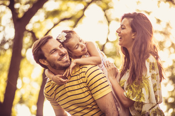 Little girl with her parents enjoy in nature. Portrait.