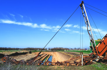 old bucket excavator of transverse dripping conducts the development of a quarry and extraction of clay