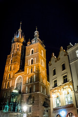 Fototapeta na wymiar Basilique Sainte-Marie sur la Place Rynek Głowny à Cracovie de nuit