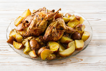 Baked quails with potatoes homemade on a plate