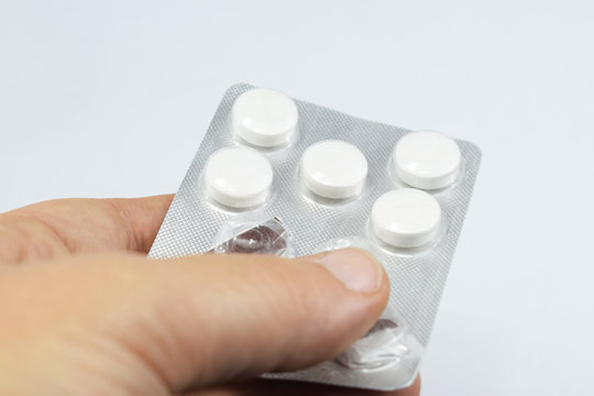 hand gives pills in a package of tablets prescribed by a doctor,